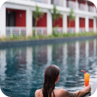 woman in a pool with a cocktail